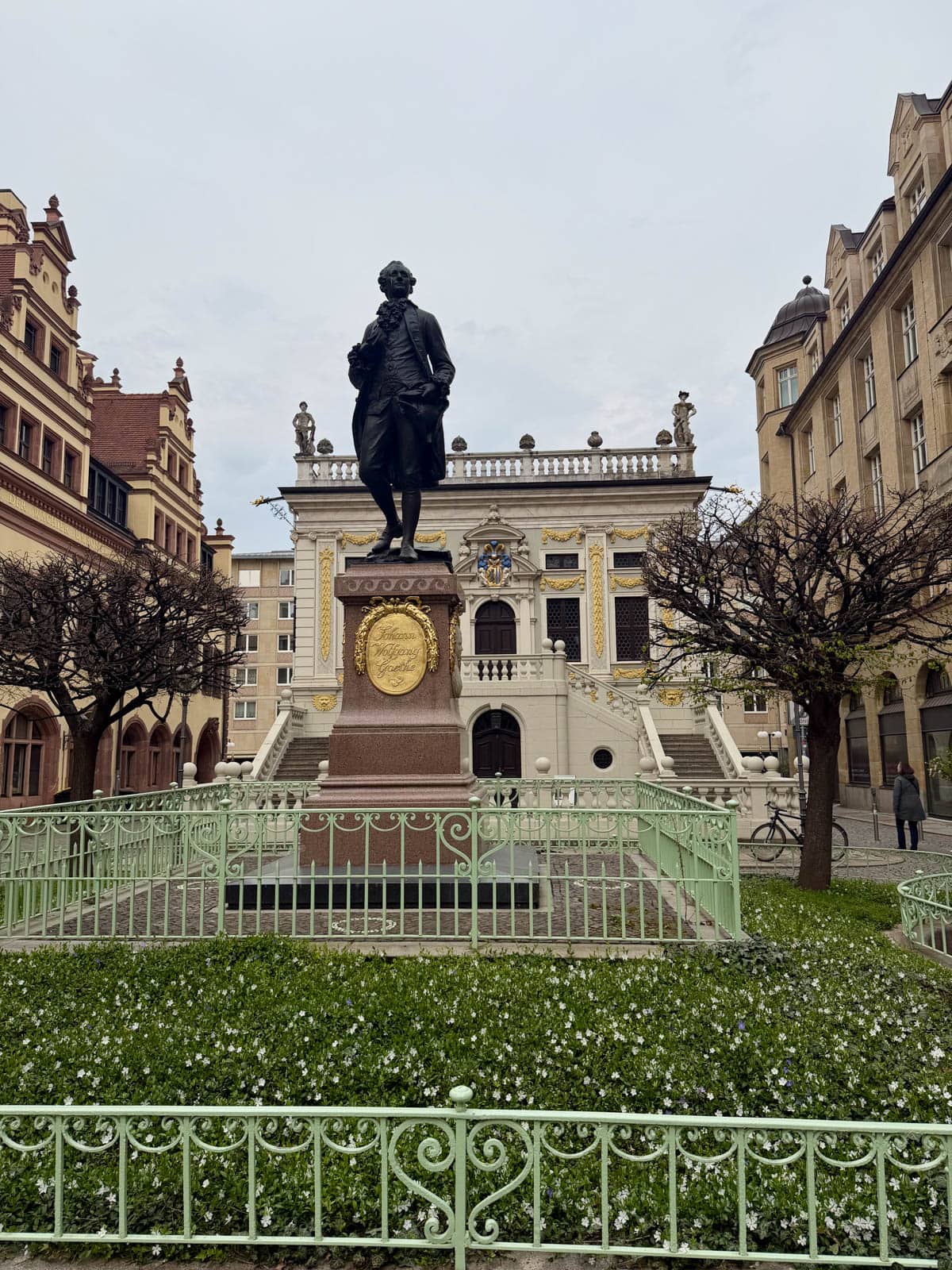 Statue of a man in front of a historic building.