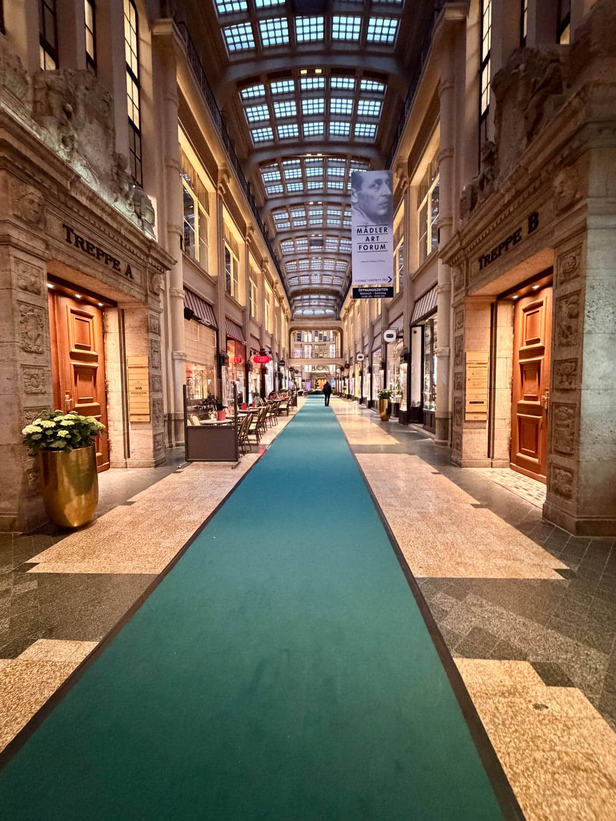 A long carpeted corridor with shops on either side.
