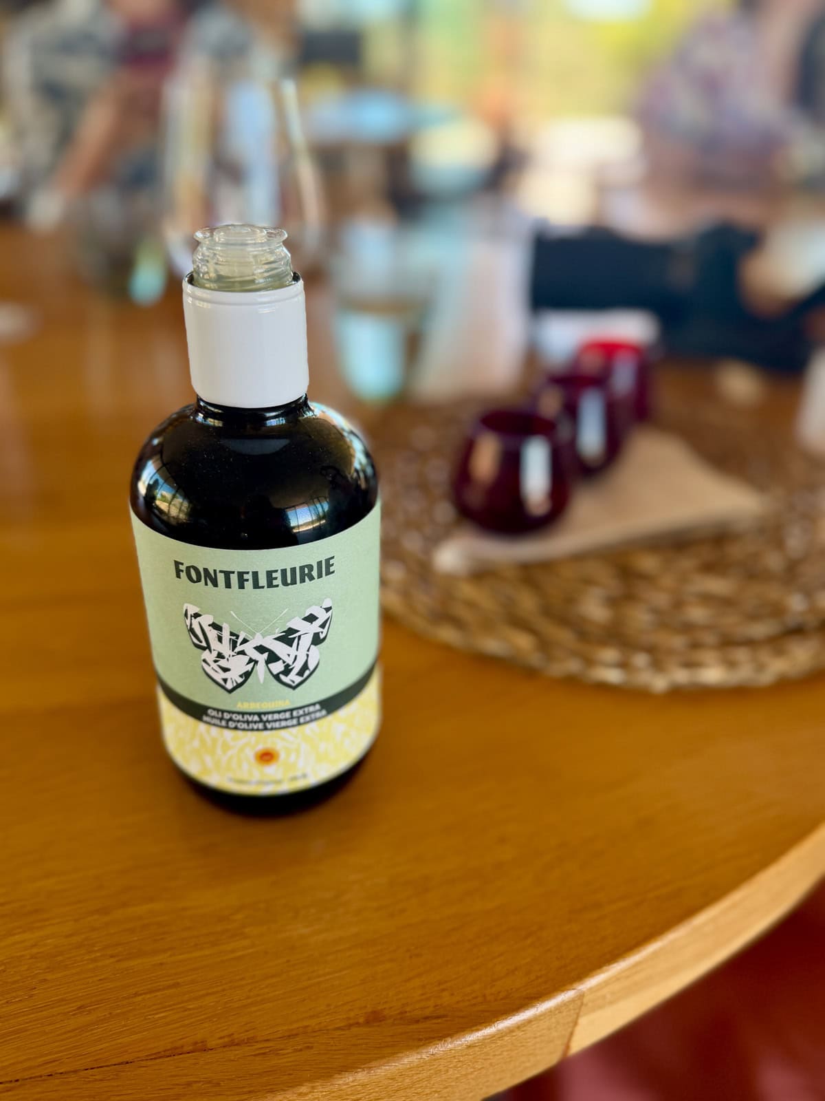 Small bottle of olive oil on a wood table.