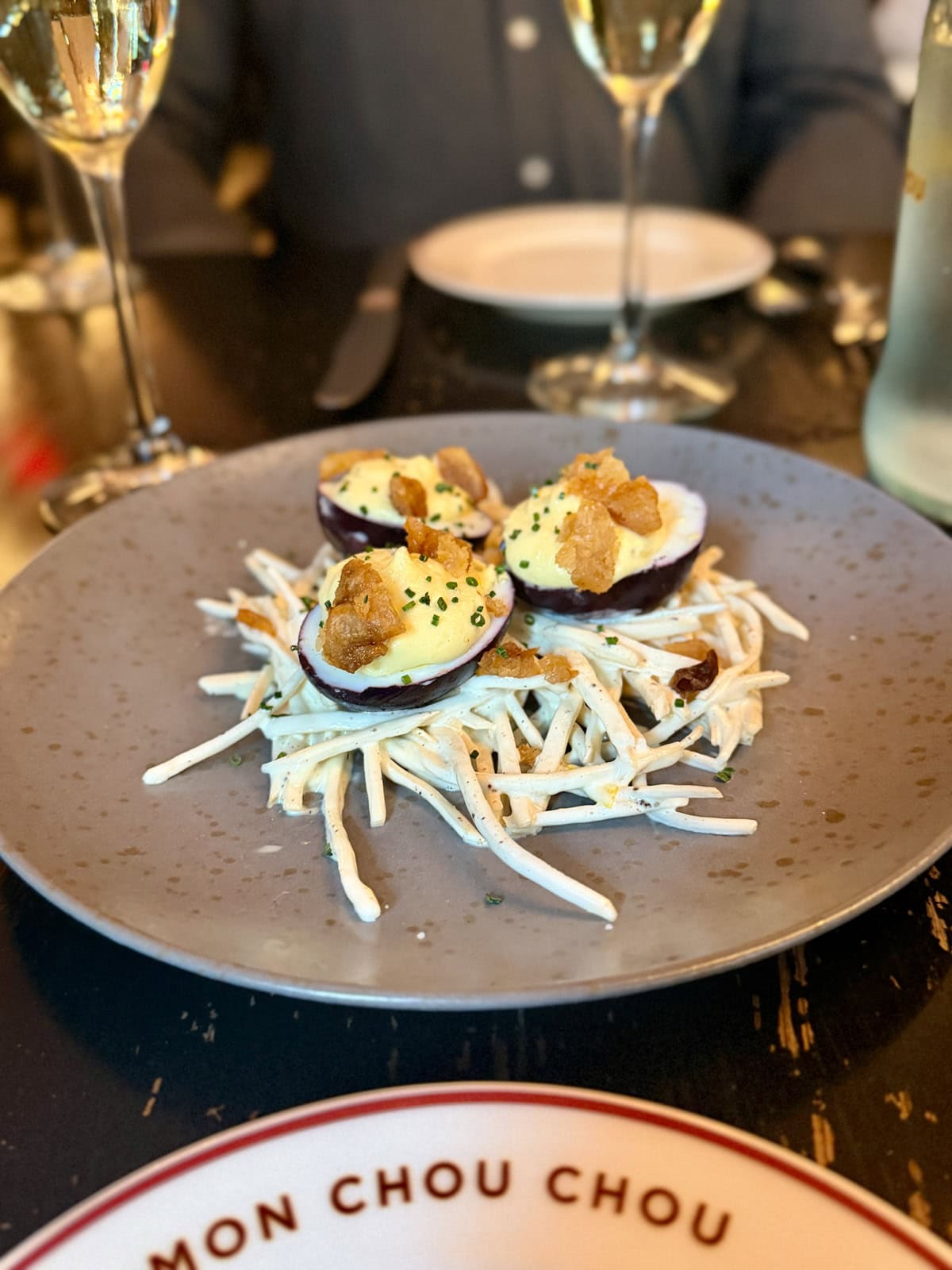 Deviled eggs with crispy topping on a grey plate.